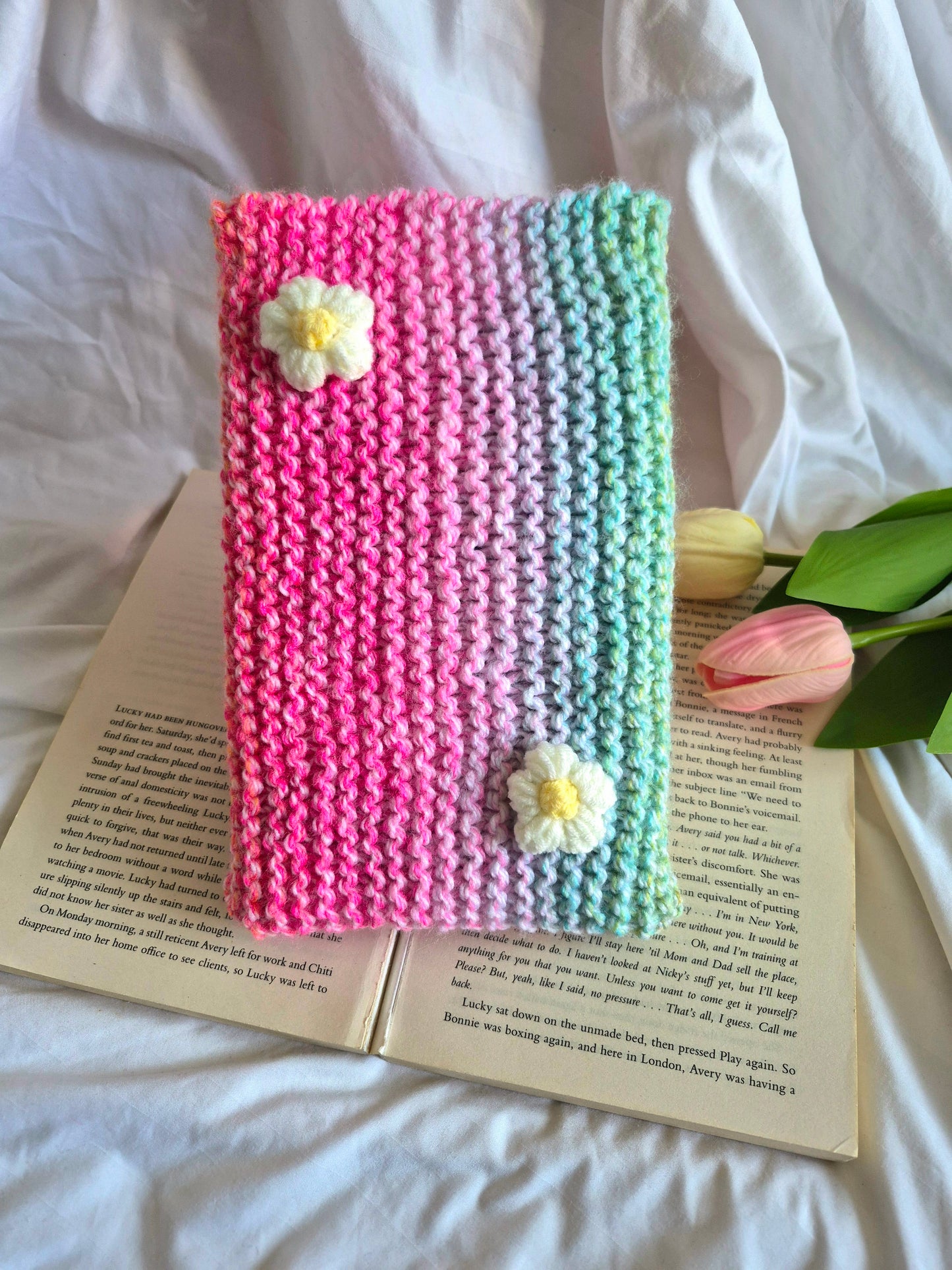 Rainbow knitted book sleeve with white flowers