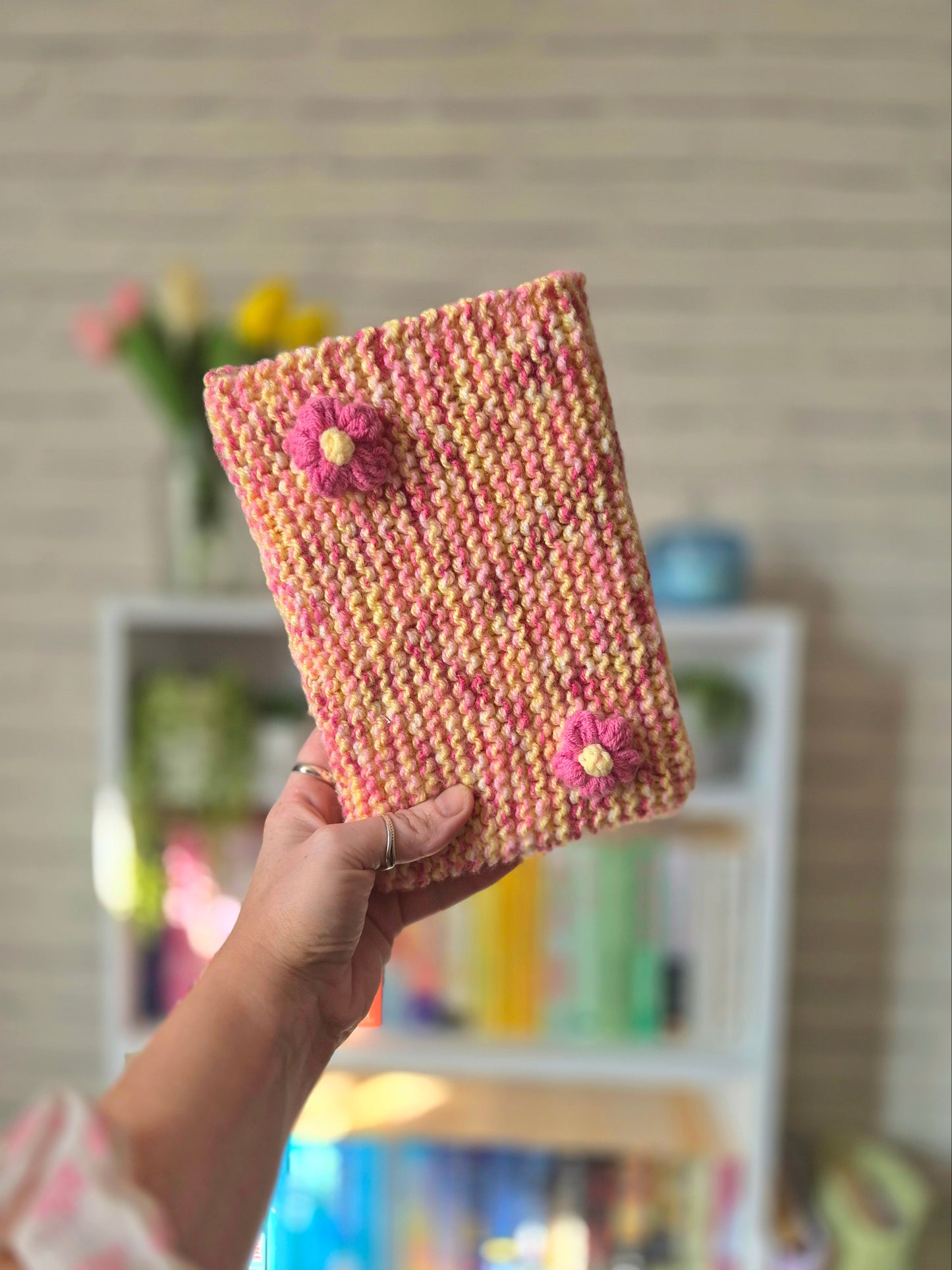 Pink and yellow Knitted book sleeve with pink flowers