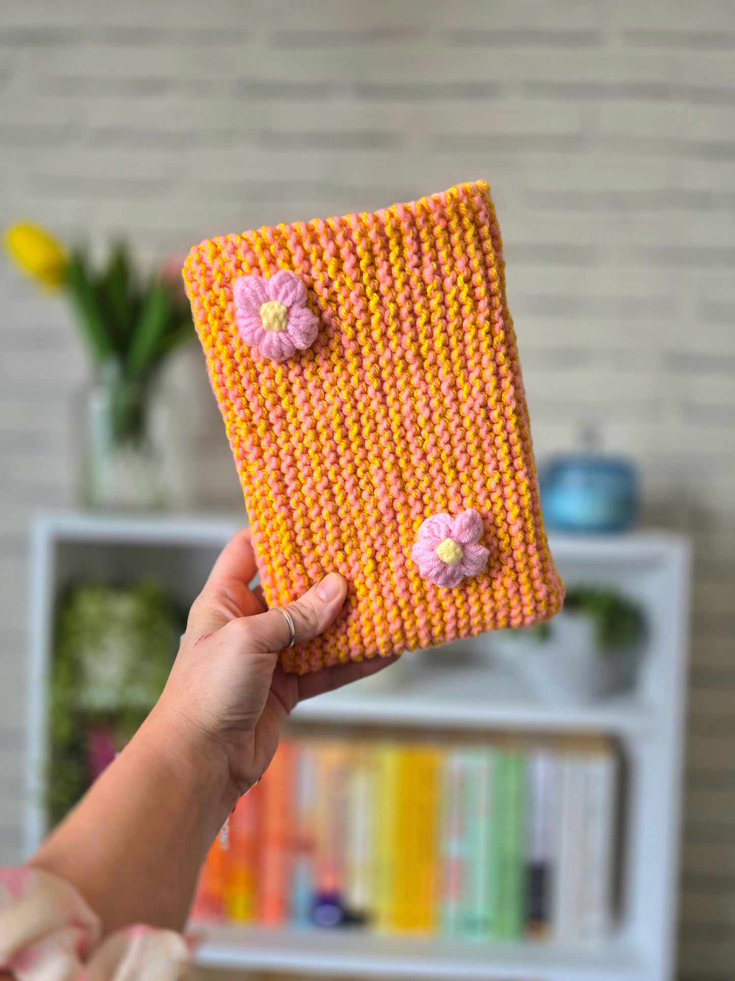 Orange and Pink Knitted book sleeve with pink flowers