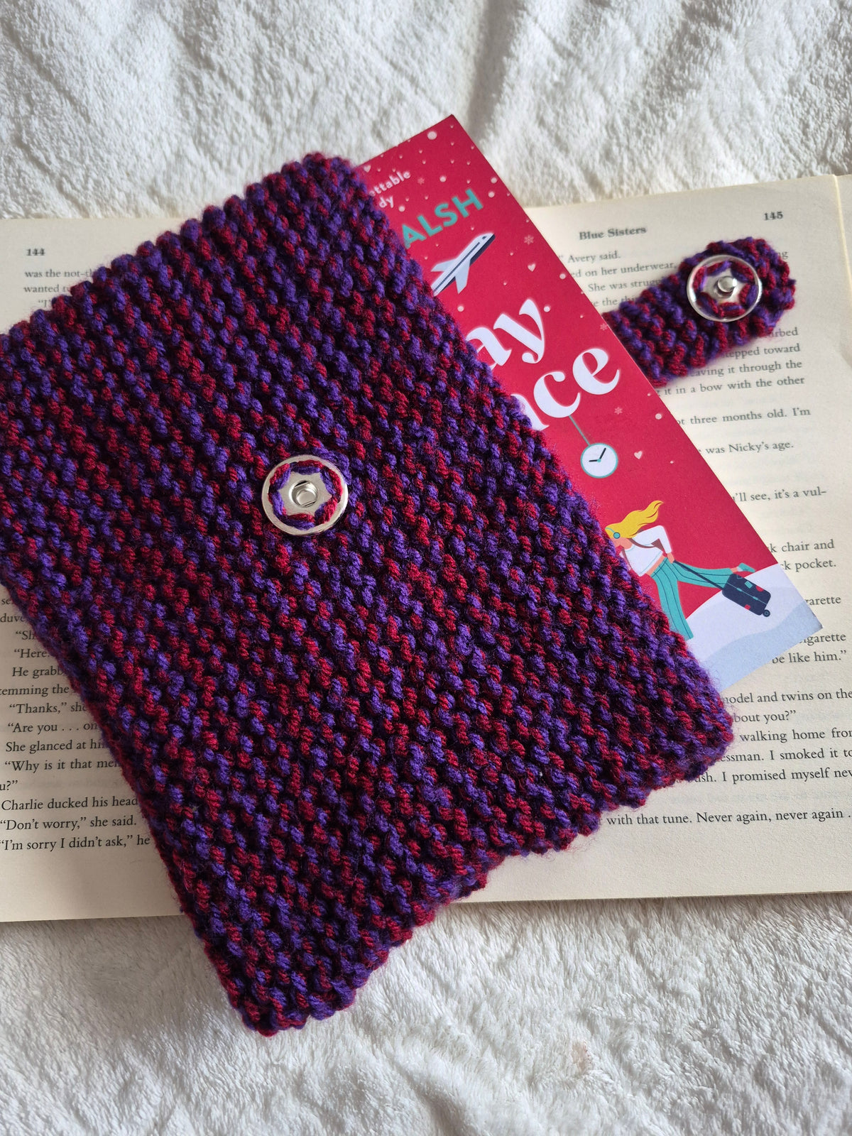 Purple and red knitted book sleeve with snap button closure