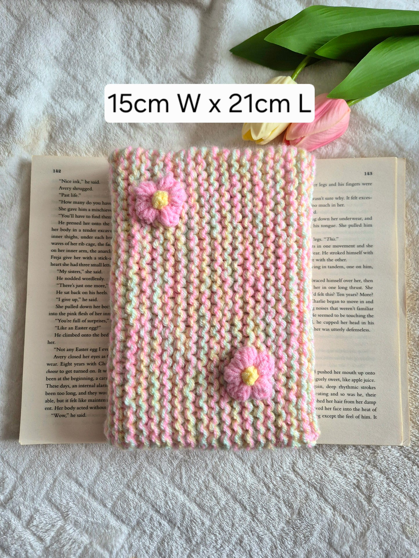 Multicoloured knitted book sleeve: Green, pink and yellow with pink flowers