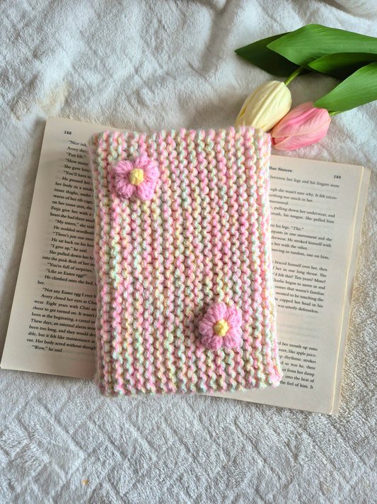 Multicoloured knitted book sleeve: Green, pink and yellow with pink flowers