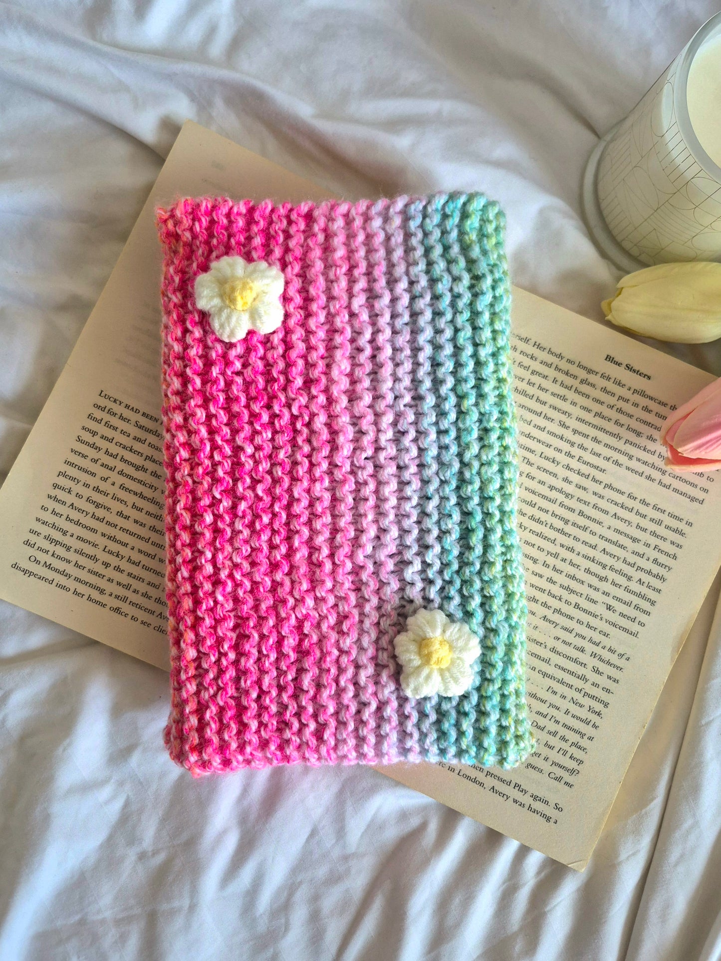Rainbow knitted book sleeve with white flowers