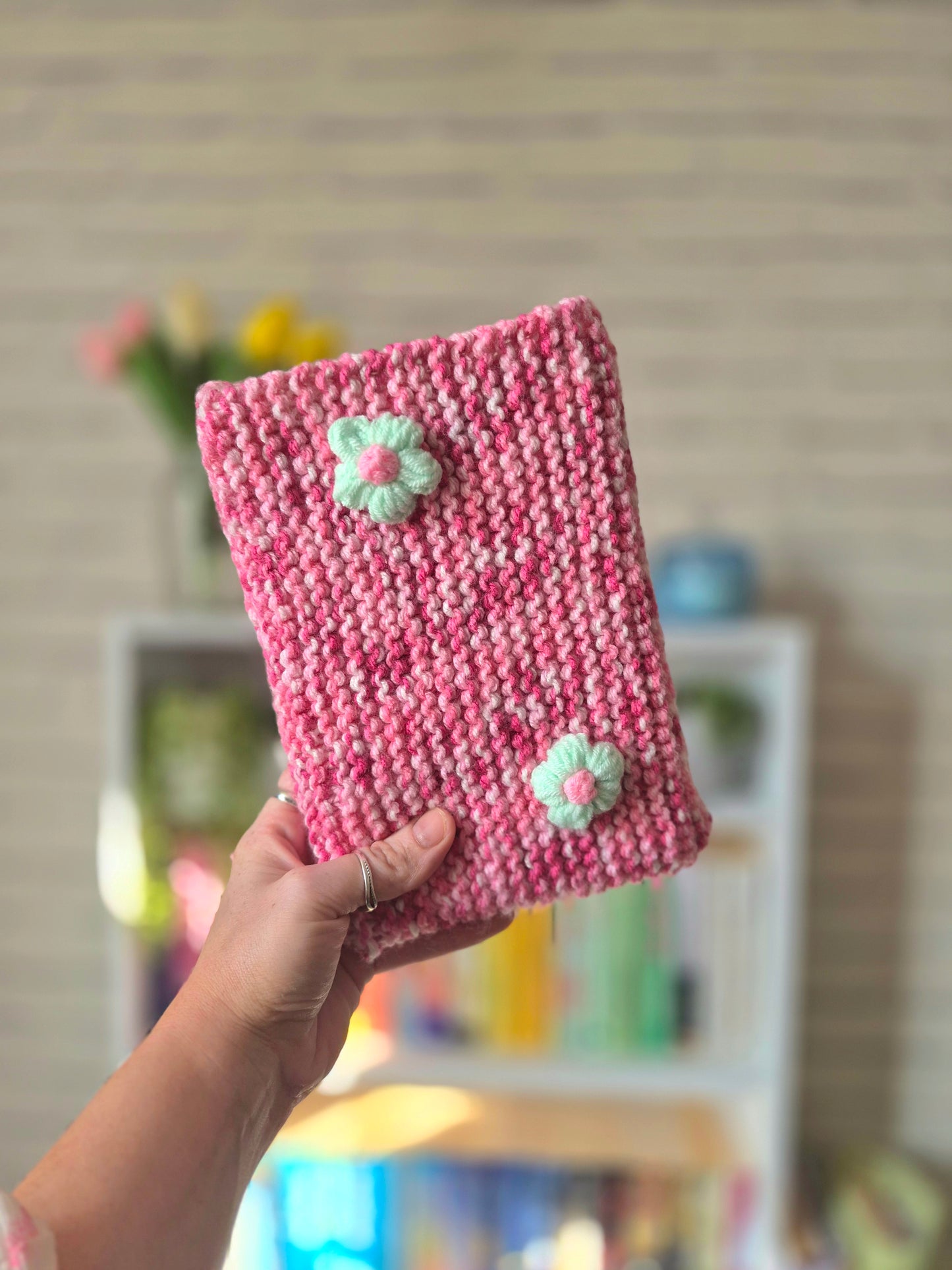 Pink and white Knitted book sleeve with green flowers