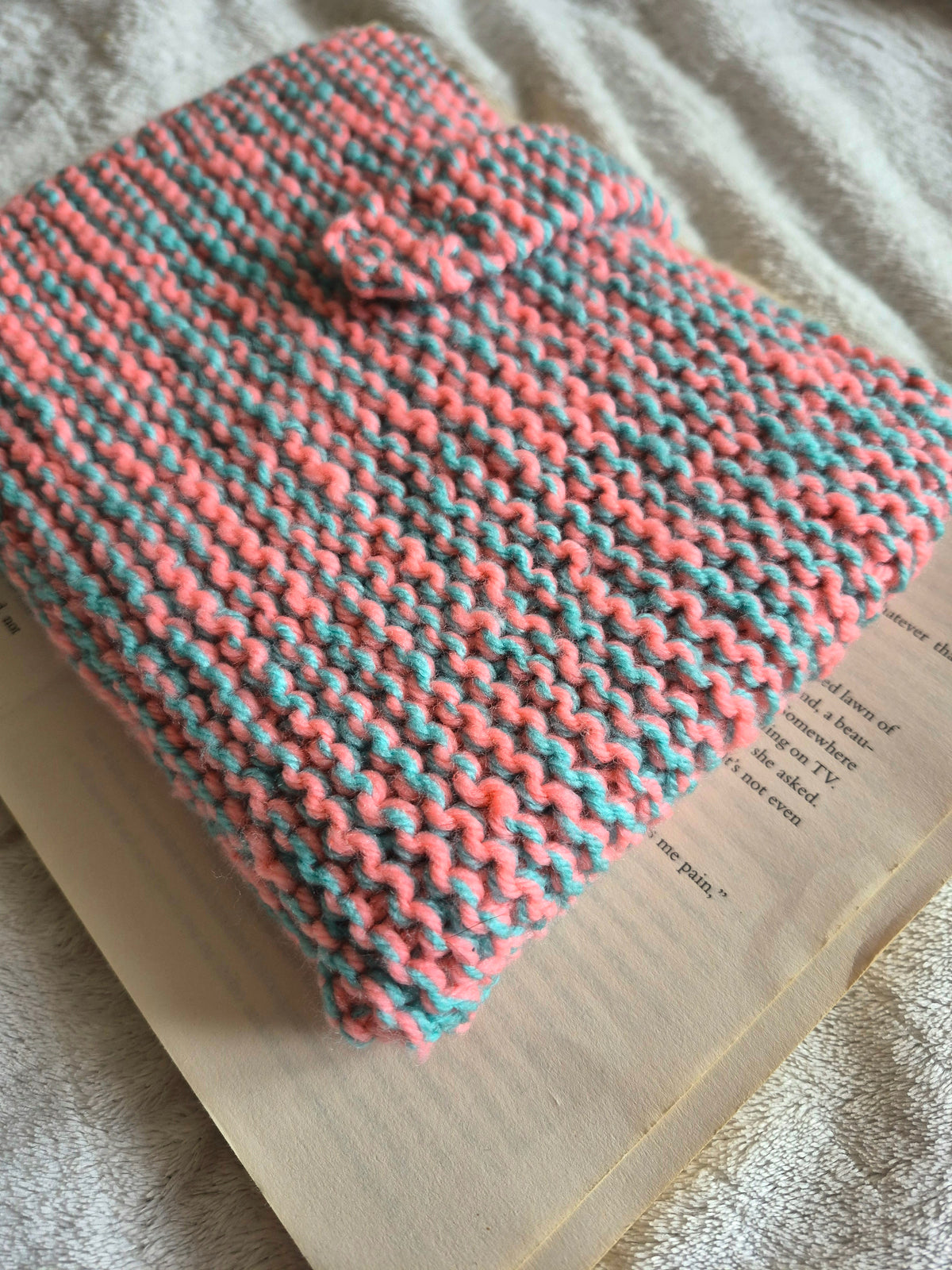 Pink and blue knitted book sleeve with snap button closure