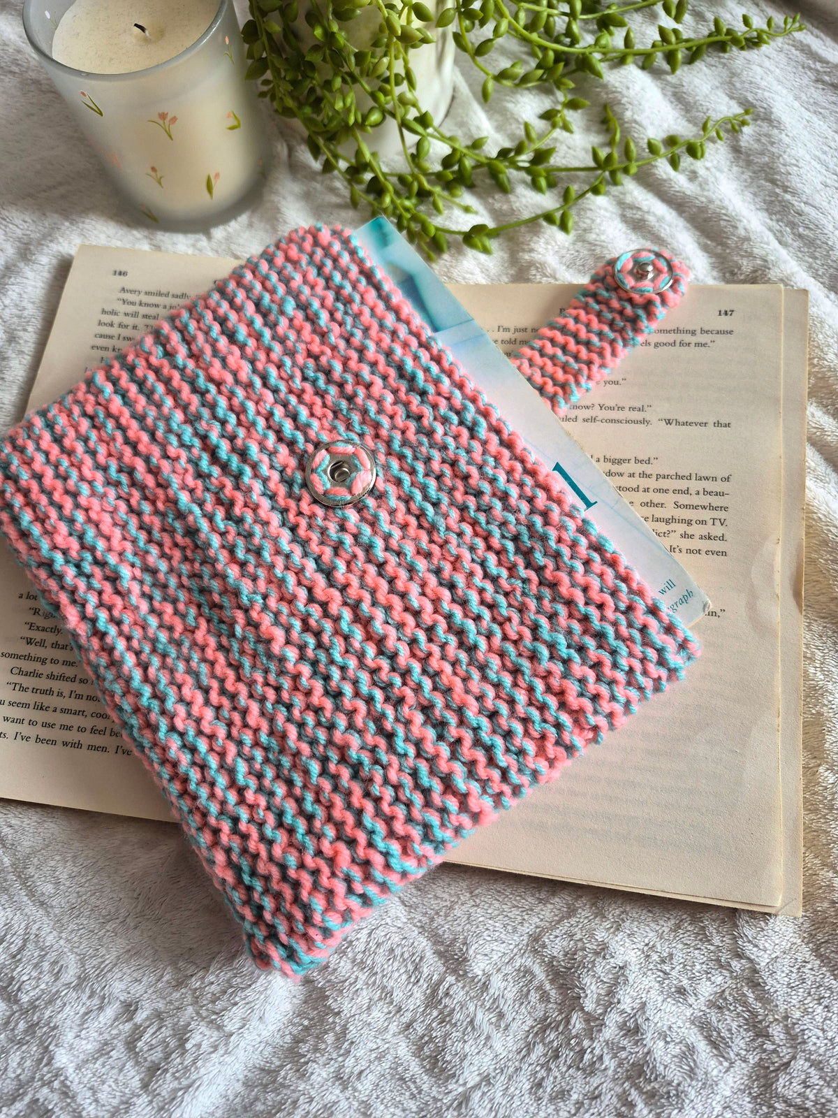 Pink and blue knitted book sleeve with snap button closure