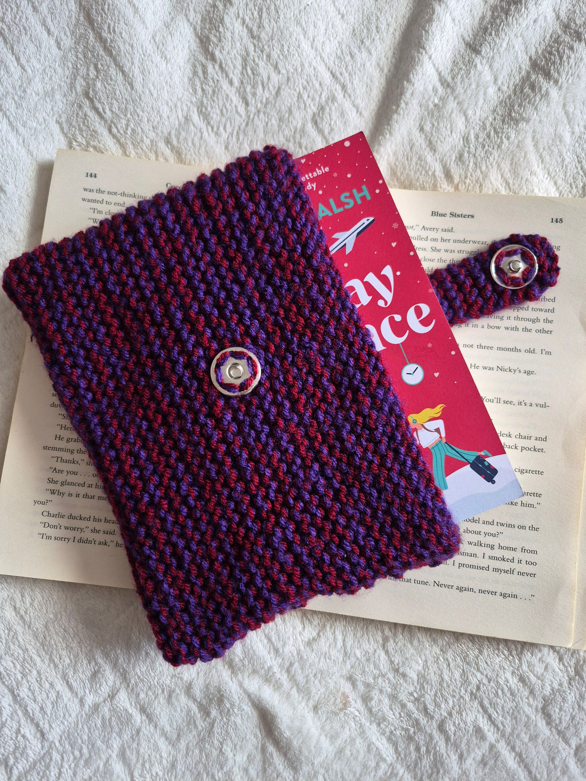 Purple and red knitted book sleeve with snap button closure